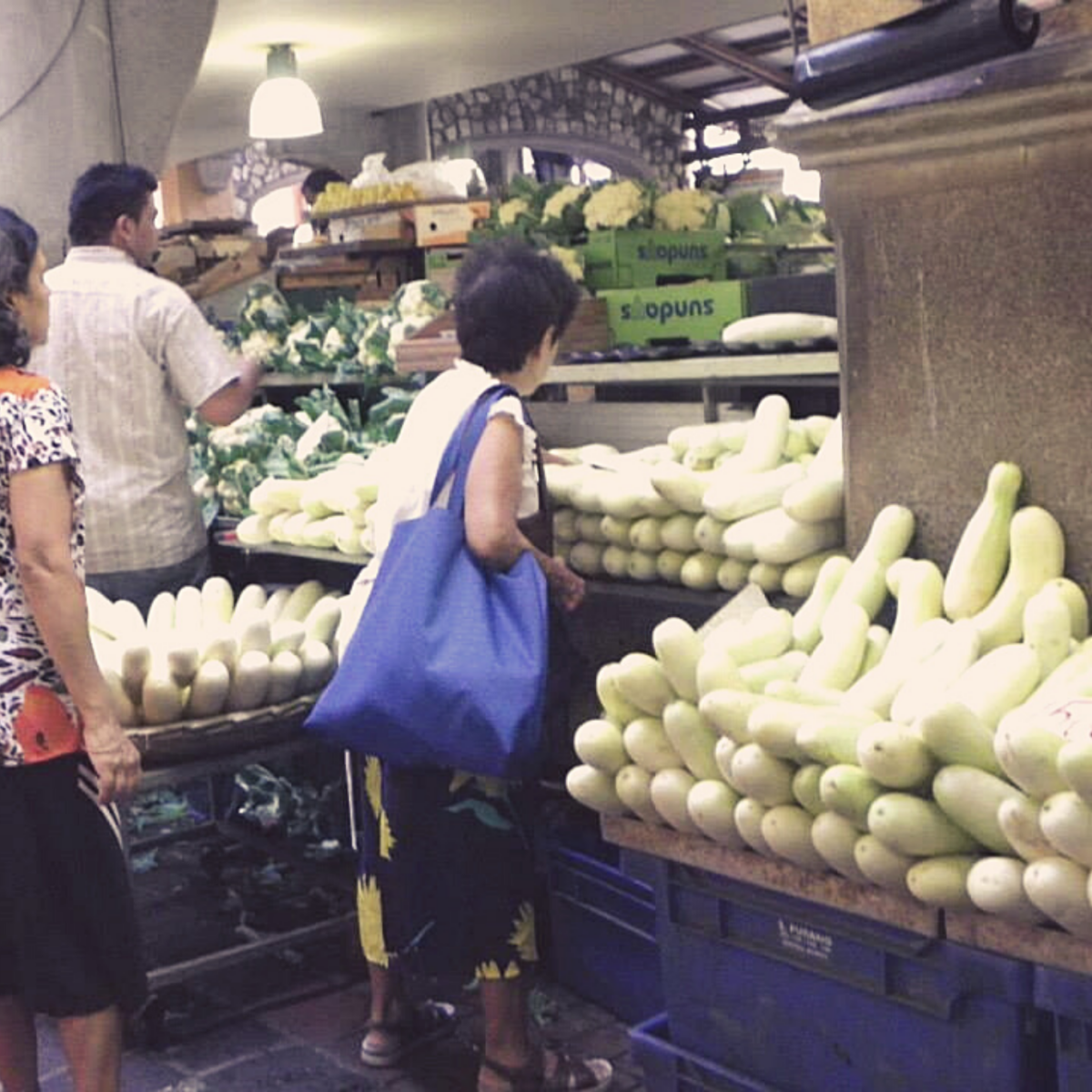 Bazaar Port Louis - White Cucumber Display with two women and one man in front.