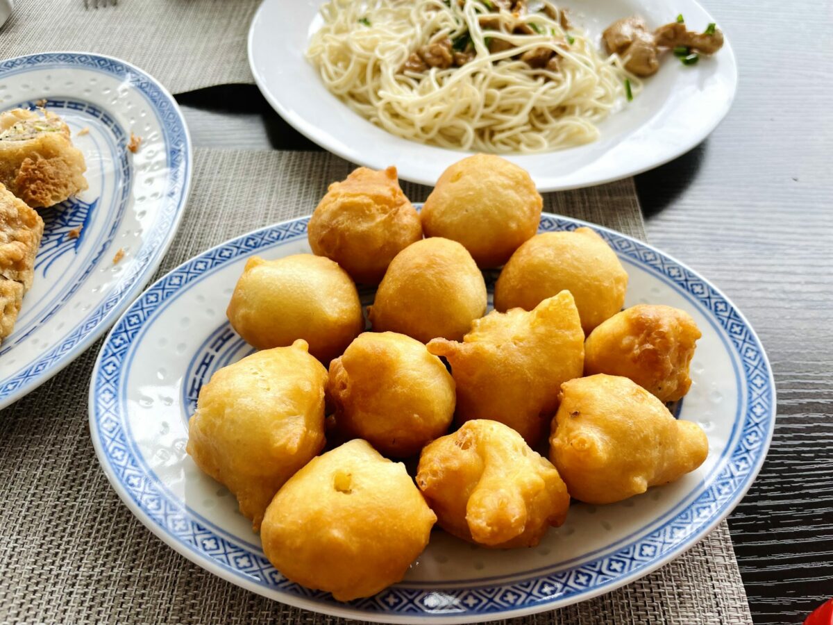 Mauritian chicken croquette and hakien on Chinese blue dragon and white porcelain oval plates. Mine bouillie topped with chicken in the back on white round plate.