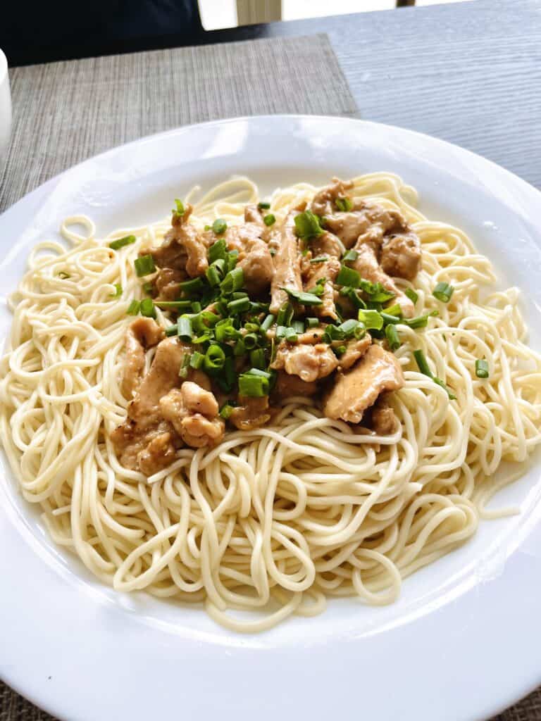 Mauritian mine bouillie with chicken and chopped green onion on top in a white plate. Noodle House Restaurant.