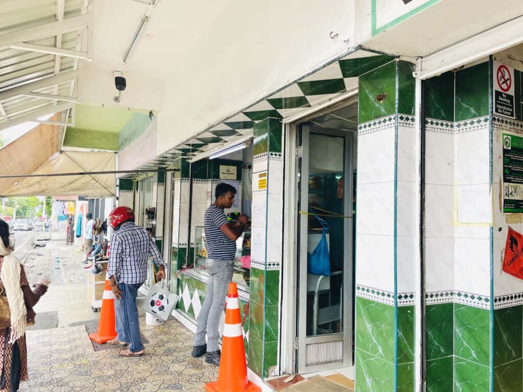 Patisserie Nabeel Plaine Verte, white and green building with orange cones.