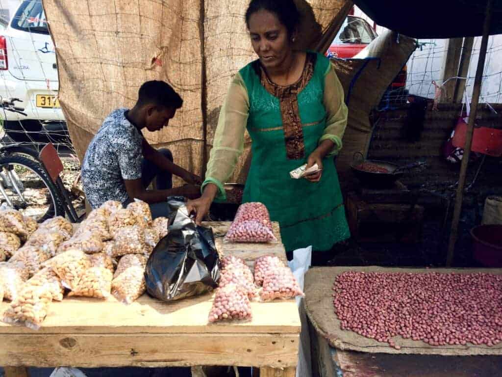 Mauritian Pistache grillé (grilled peanuts) shelled and unshelled - Street vendor with a lady and young man in the background.