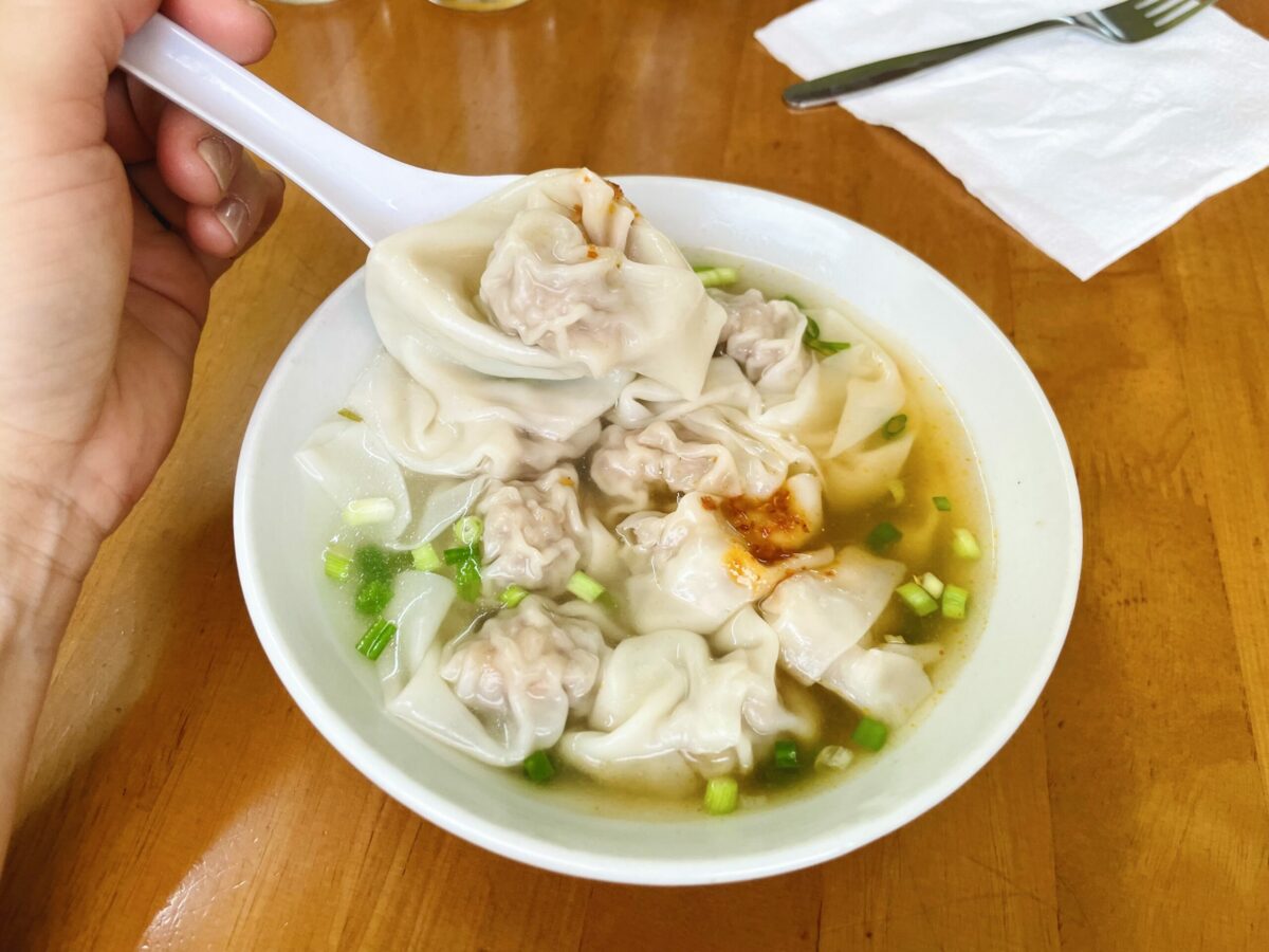 Wantan soup in large bowl with green onion and red chili paste