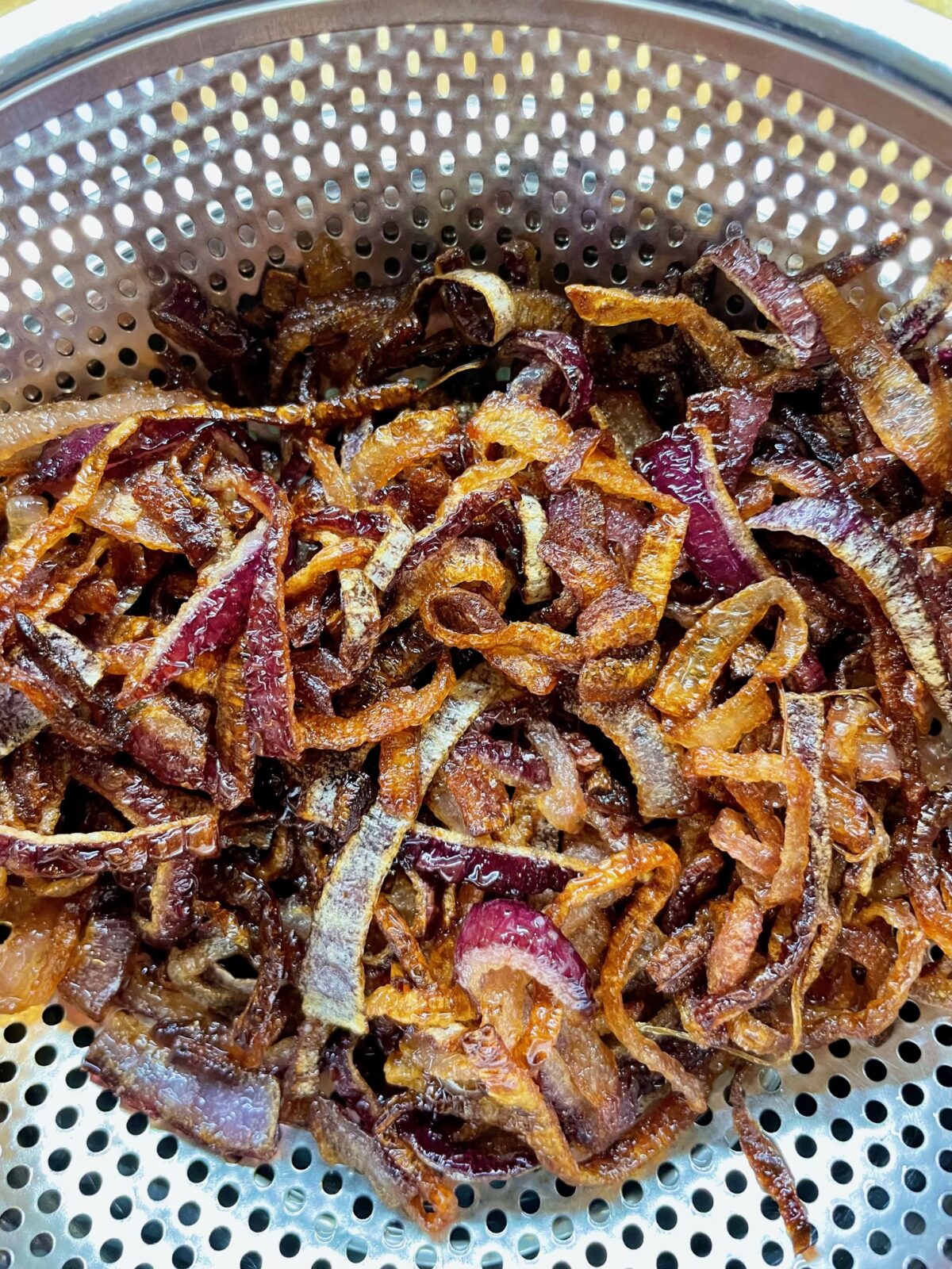 Fried red onion in colander
