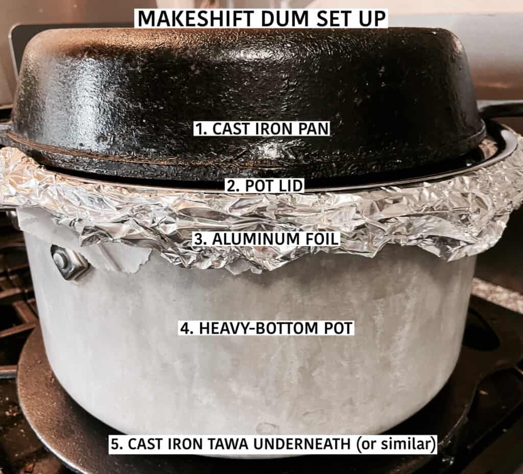 Set up for makeshift briani dum: Heavy bottom stockpot with aluminum foil and lid on. Cast iron pan on top and cast iron tawa underneath.