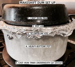 Set up for makeshift briani dum: Heavy bottom stockpot with aluminum foil and lid on. Cast iron pan on top and cast iron tawa underneath.