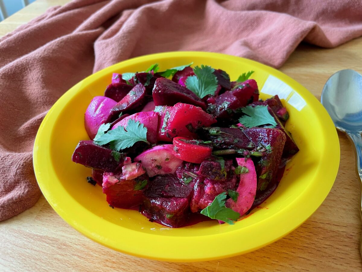 Mauritian Beet and Potato Salad in a yellow plastic plate. Garnished with fresh cilantro.