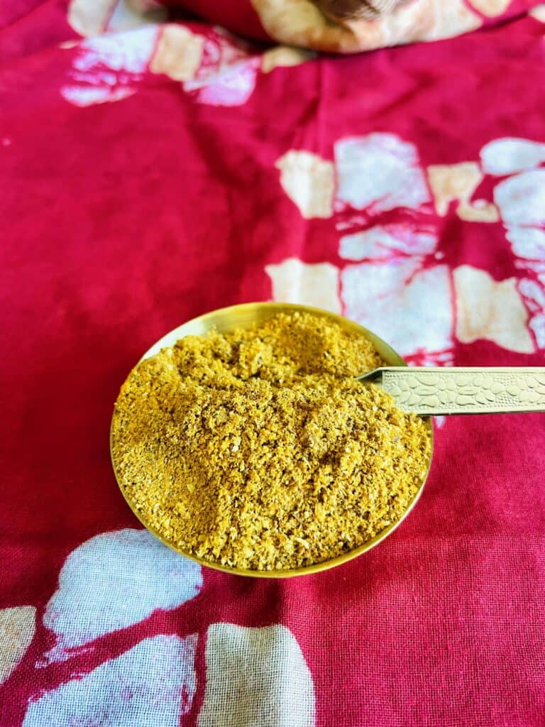 Basic Indian curry powder in stainless steel bowl with spoon.