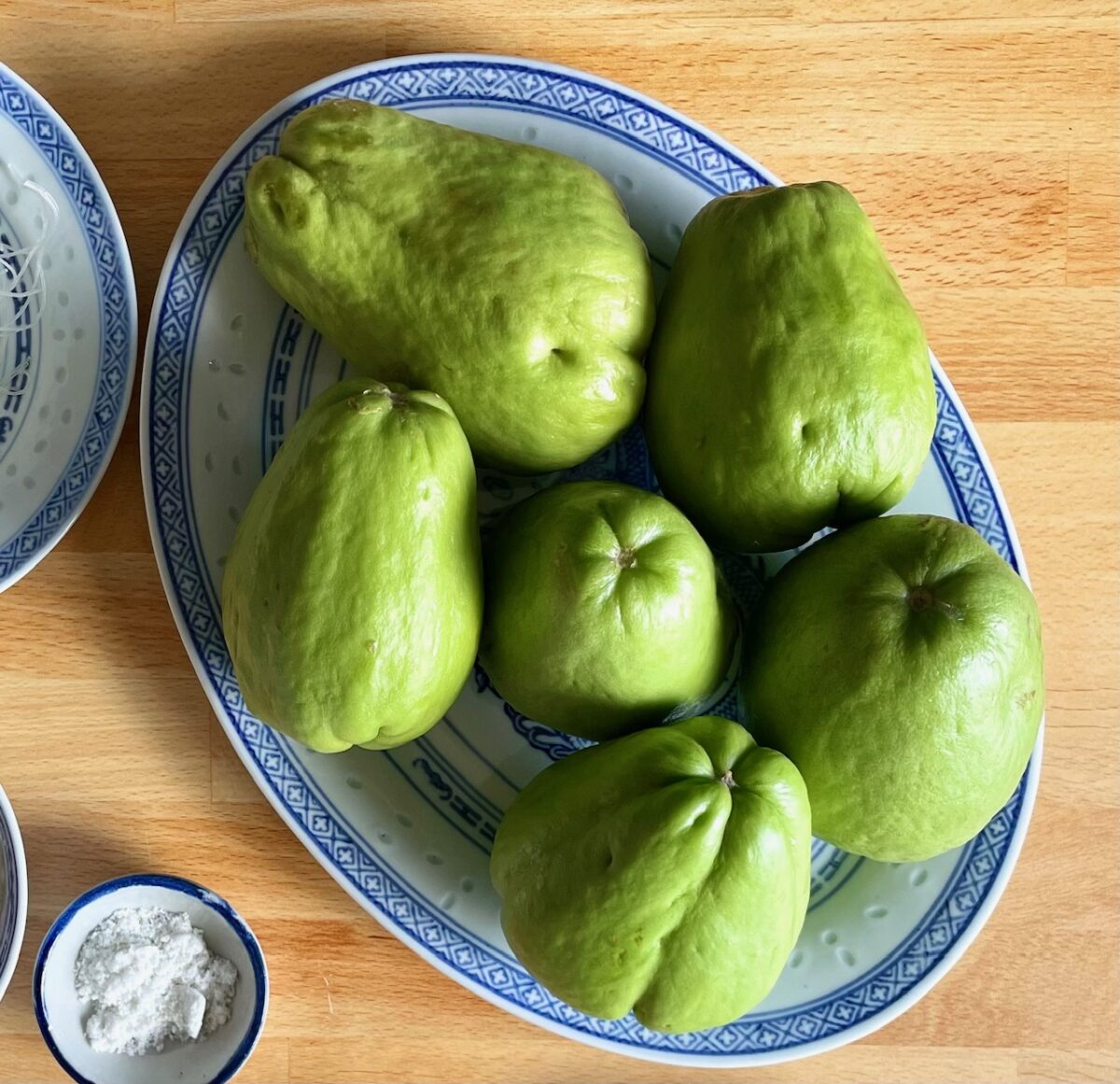 Chayotes (or Mauritian chouchou) in oval Chinese plate. Salt in mini bowl next to it.