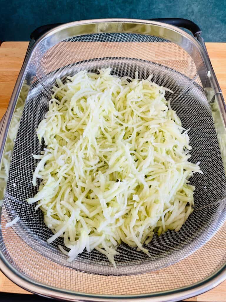 Shredded Chayote Squash Chouchou in colander.